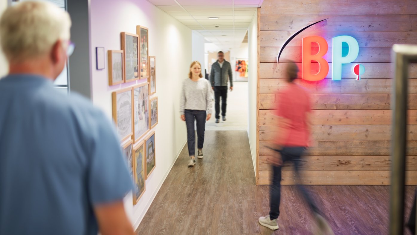 BP employees at the company headquarters in Cologne walk through the corridor.
